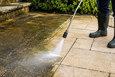 Pressure washing service in Kingston cleaning a concrete patio